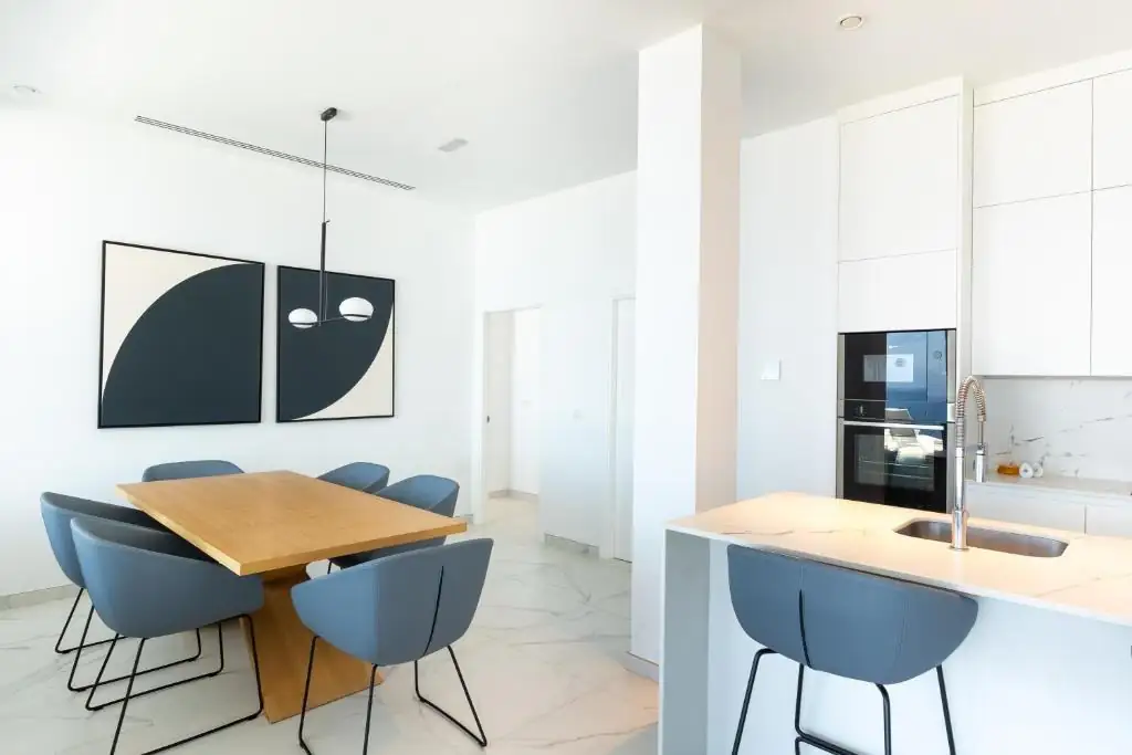 Comedor con dos obras abstractas enmarcadas junto a la cocina