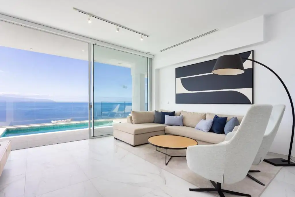 Salón con vistas al mar y obra abstracta enmarcada sobre el sofá